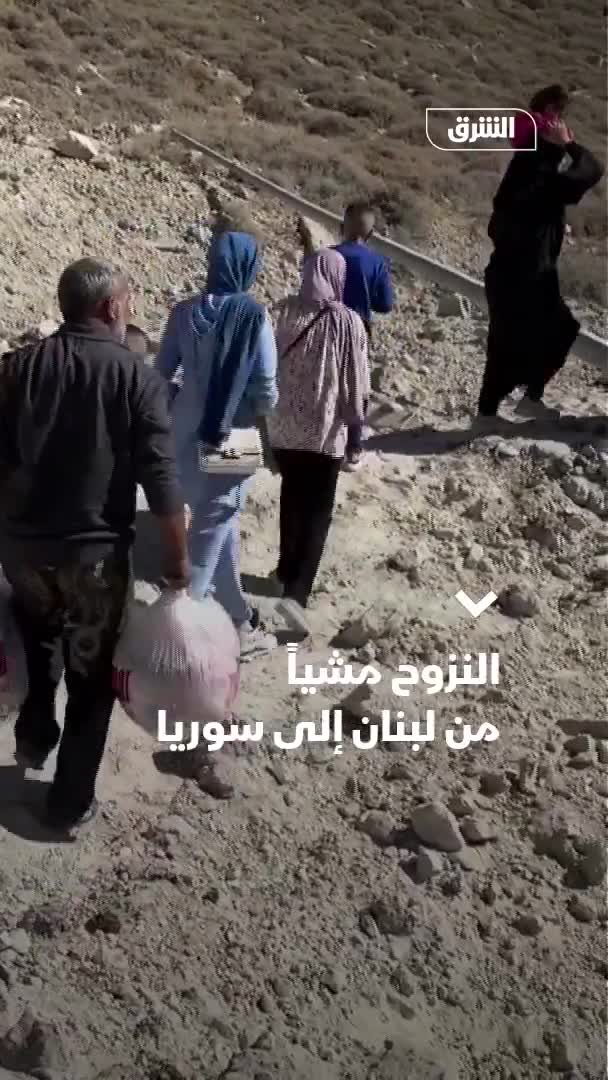 Displaced people from Lebanon head to the Al-Masnaa border crossing with Syria on foot after an Israeli raid cut off the road leading to it