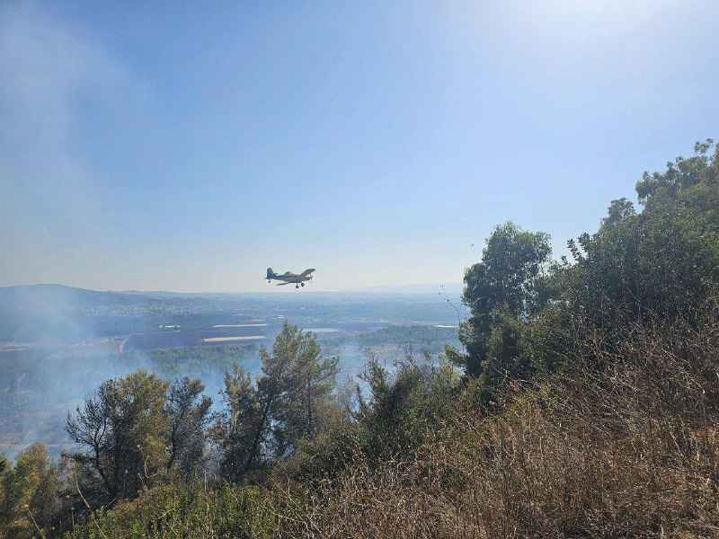 Los servicios de emergencia israelíes utilizan aviones para extinguir un incendio que se produjo en el asentamiento de Shlomi después de que un misil de Hezbolá lo alcanzara.